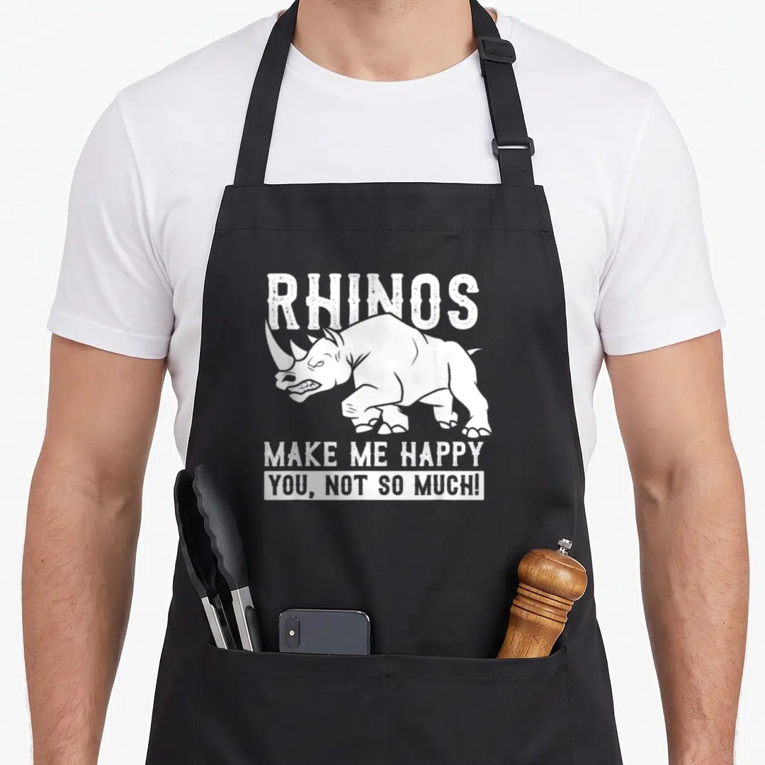 Rhino animal apron - White distressed rhinoceros illustration with the text RHINOS MAKE ME HAPPY YOU NOT SO MUCH — shown on a black cotton canvas apron against a white background