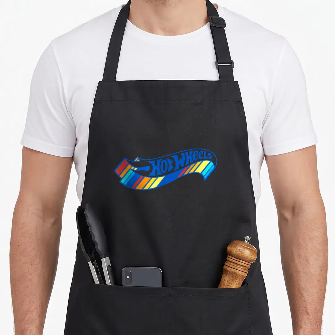 Colourful wheel apron - Hot Wheels logo on waving ribbon with blue red orange yellow stripes — shown on a black cotton canvas apron against a white background