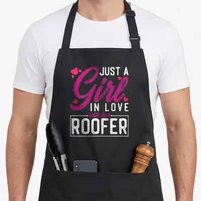 Roofer wife apron - Stacked text Just A Girl In Love With Her Roofer with small hearts — shown on a black cotton canvas apron against a white background