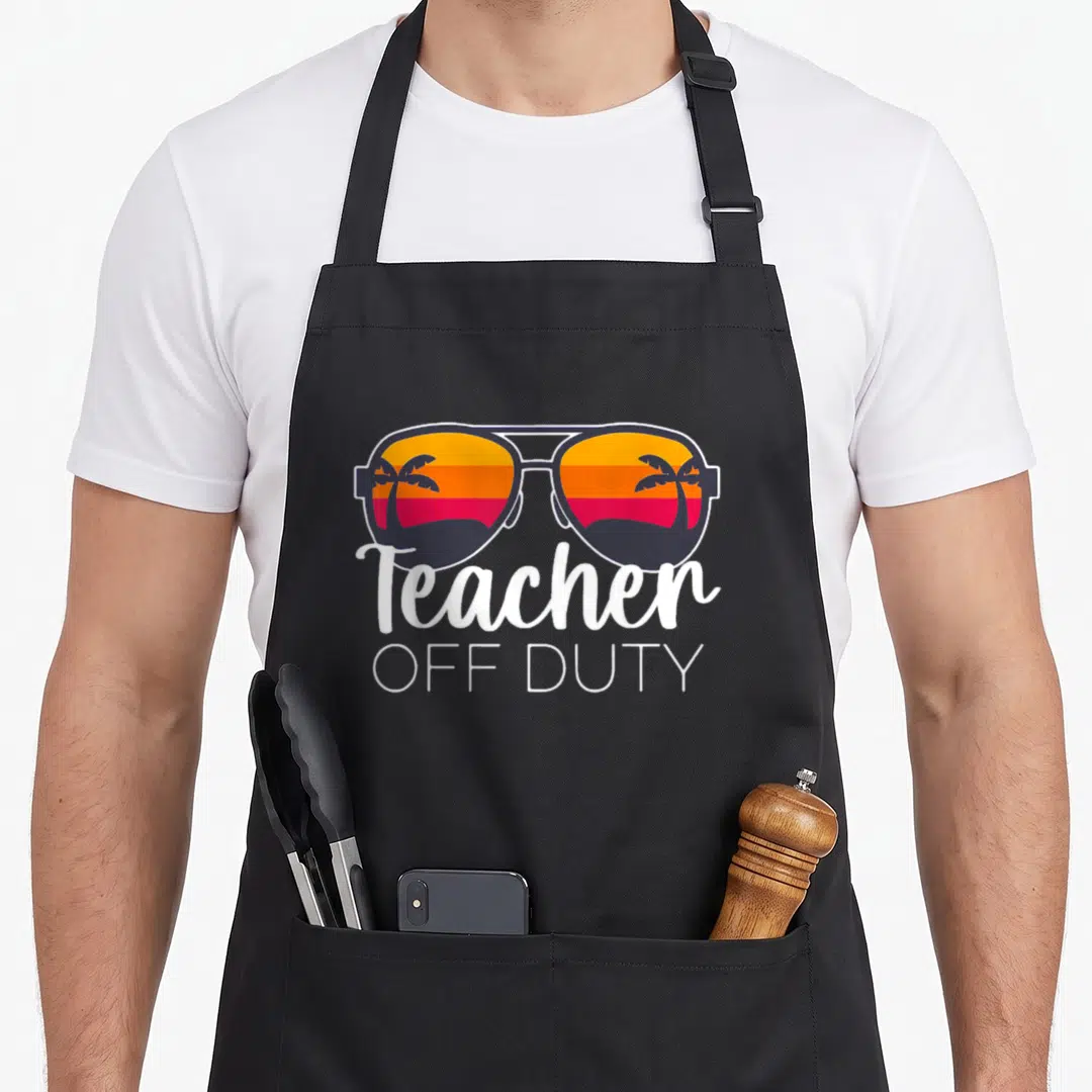 Duty teacher apron - Retro sunglasses reflecting palm tree sunset with stacked white Teacher OFF DUTY text below — shown on a black cotton canvas apron against a white background