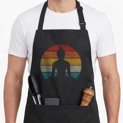 Buddha yoga spiritual apron - Grey Buddha silhouette inside a circle of red orange yellow white and blue horizontal — shown on a black cotton canvas apron against a white background