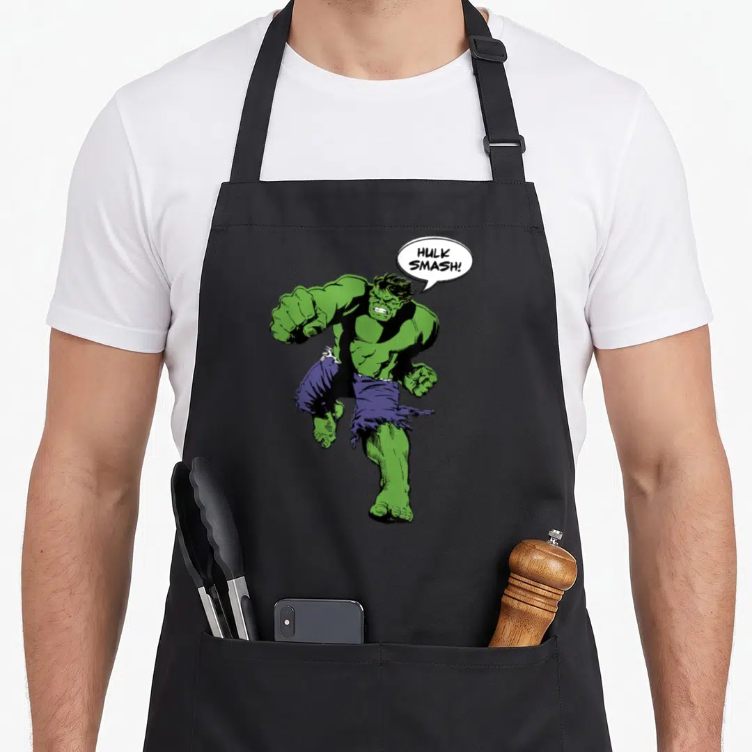 Smash hobby apron - Hulk in dynamic pose with speech bubble reading HULK SMASH! in green purple and white — shown on a black cotton canvas apron against a white background