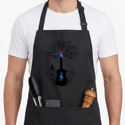 Music tree apron - Surreal guitar with branching heart, raven, and treble clef in black blue red — shown on a black cotton canvas apron against a white background