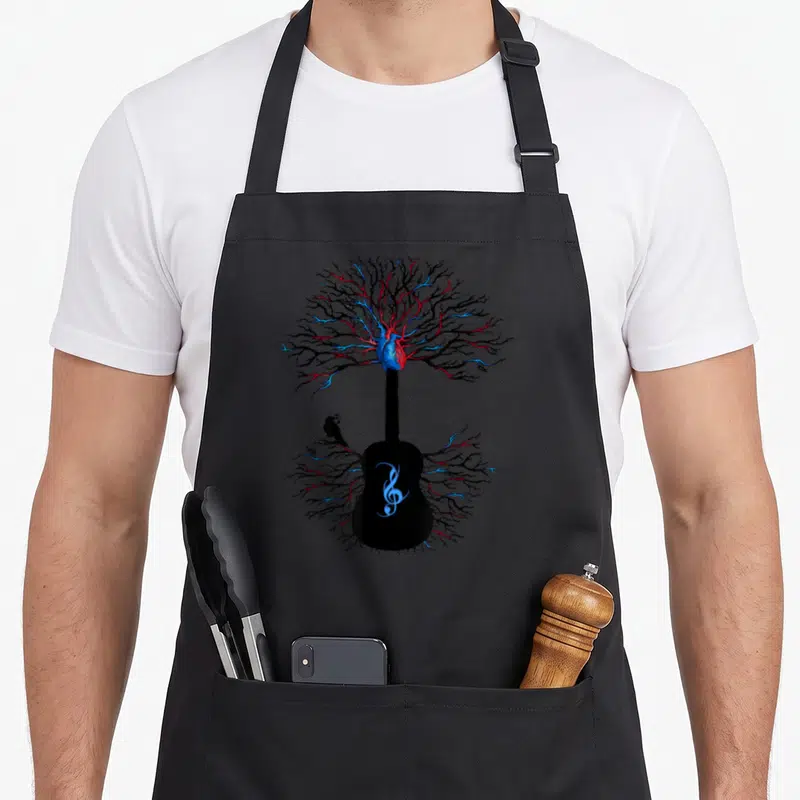 Music tree apron - Surreal guitar with branching heart, raven, and treble clef in black blue red — shown on a black cotton canvas apron against a white background