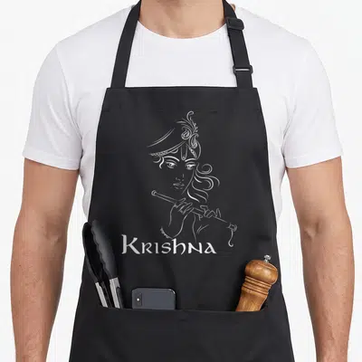 Hinduism diwali apron - White line art of Krishna playing flute above text Krishna on black background — shown on a black cotton canvas apron against a white background