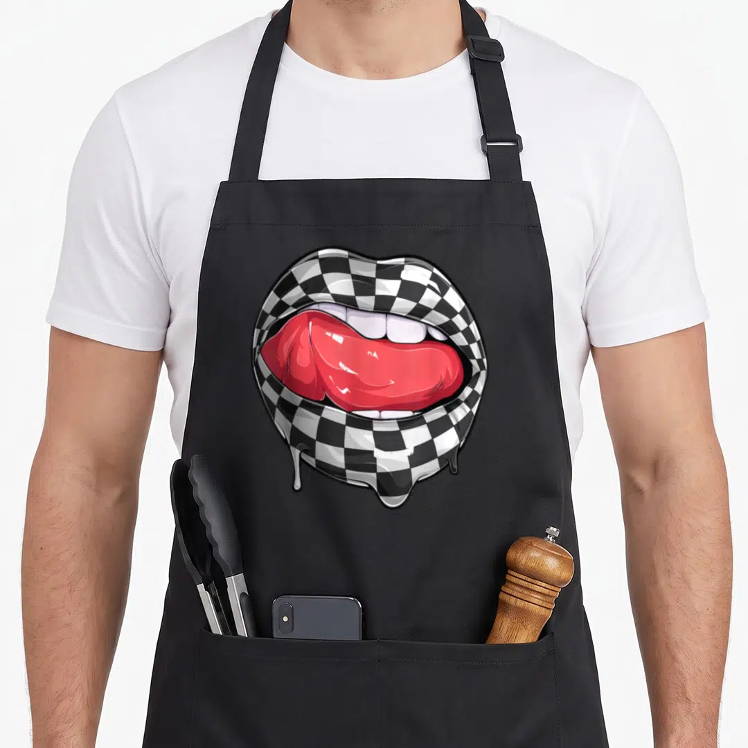 Checkered car apron - Checkerboard patterned lips with red tongue and dripping bottom lip in cartoon style — shown on a black cotton canvas apron against a white background