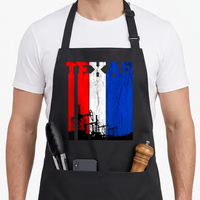 Oilfield texas apron - Distressed TEXAS text with red white blue stripes and black oil derricks — shown on a black cotton canvas apron against a white background