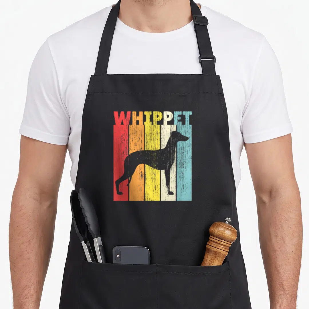 Cute whippet dog apron - Grey whippet silhouette standing before five vertical stripes in red orange yellow blue — shown on a black cotton canvas apron against a white background