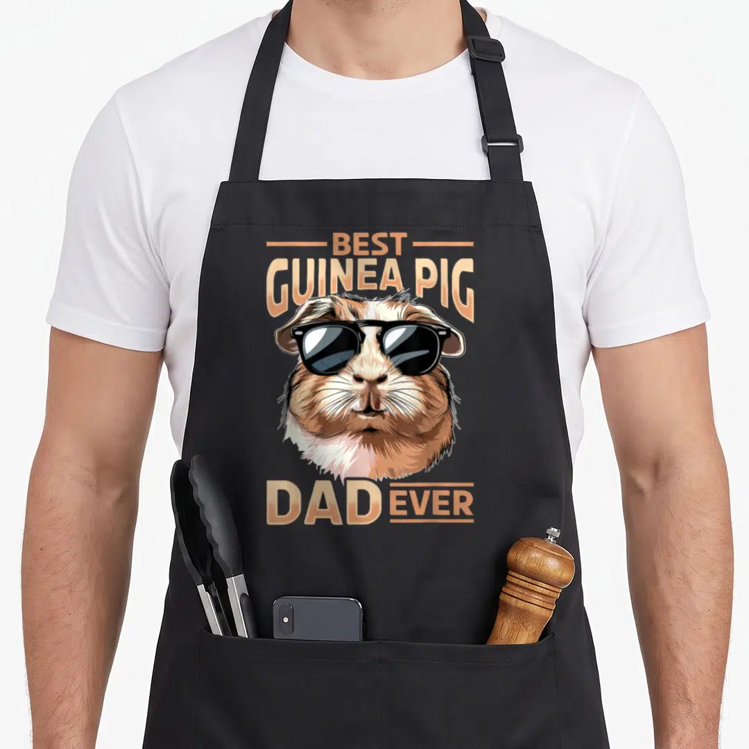 Pig pet animal apron - Cartoon guinea pig head in tan and brown fur wearing black sunglasses with best guinea pig dad — shown on a black cotton canvas apron against a white background