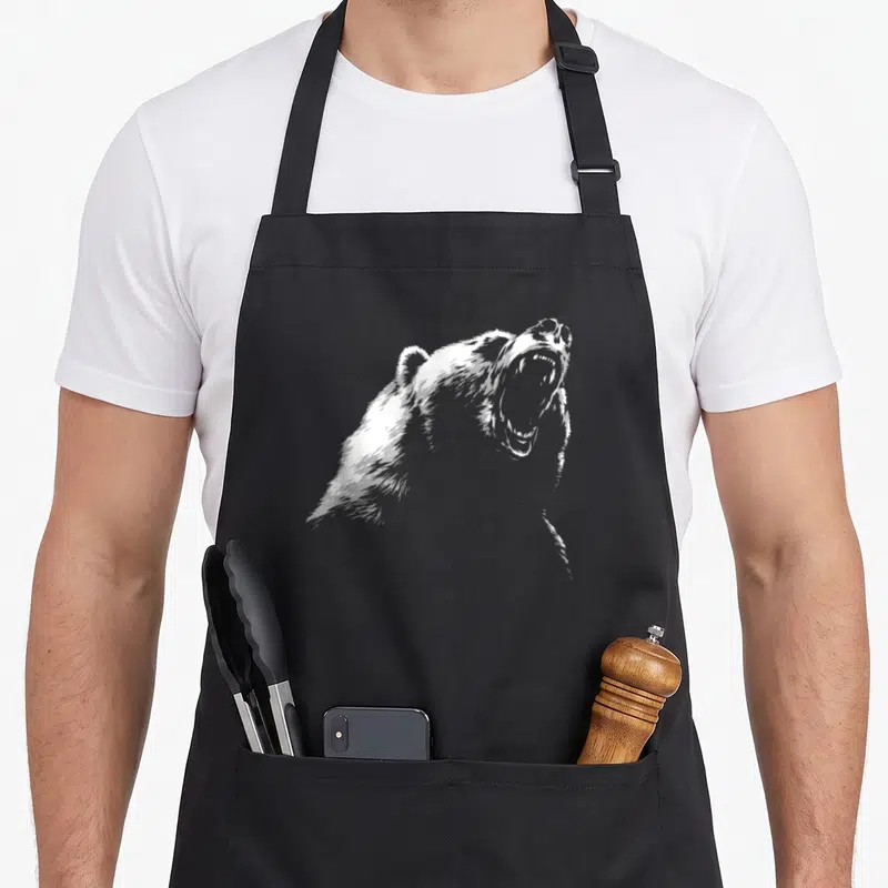 Hike bear apron - White line-art illustration of a roaring bear head and shoulders in profile — shown on a black cotton canvas apron against a white background
