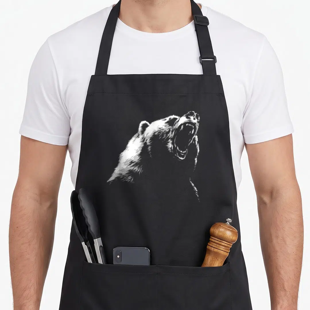 Hike bear apron - White line-art illustration of a roaring bear head and shoulders in profile — shown on a black cotton canvas apron against a white background