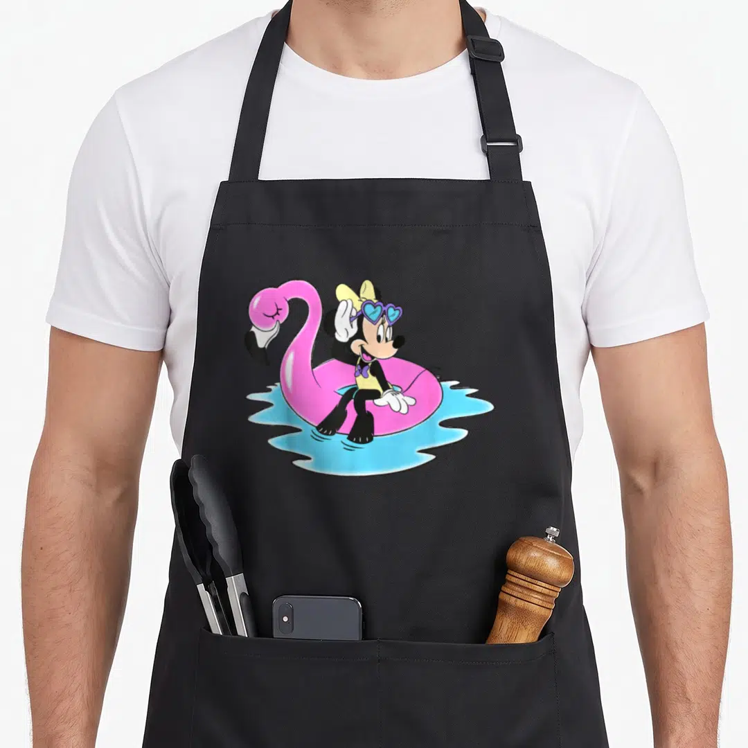 Retro flamingo apron - Minnie Mouse in pink flamingo float wearing blue heart glasses on light blue water — shown on a black cotton canvas apron against a white background