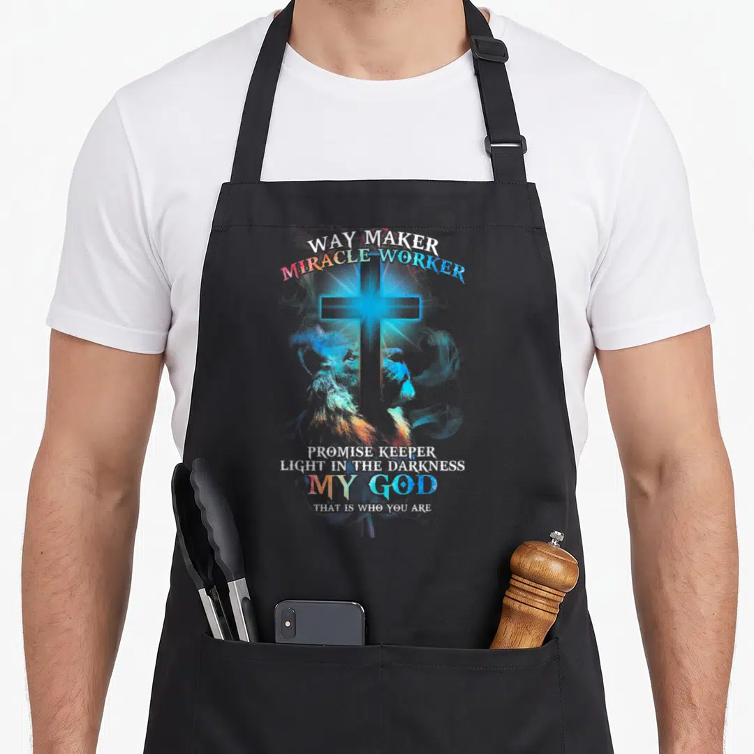Lion cross apron - Glowing cross over lion head with Way Maker Miracle Worker Promise Keeper text in blue white — shown on a black cotton canvas apron against a white background