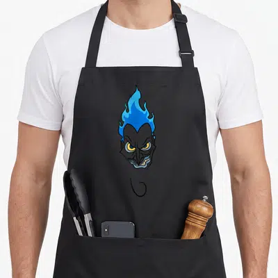Hade face apron - Cartoon grey demon head with blue flame hair and curled goatee — shown on a black cotton canvas apron against a white background