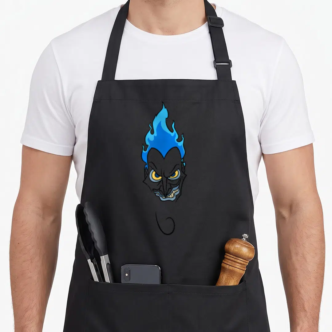 Hade face apron - Cartoon grey demon head with blue flame hair and curled goatee — shown on a black cotton canvas apron against a white background