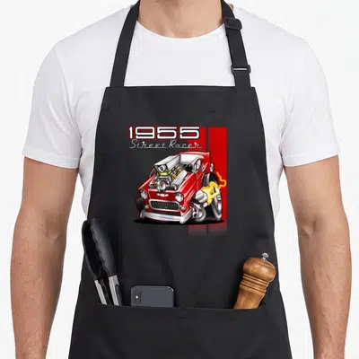 Hot 50s apron - 1955 Street Racer text above red cartoon car with exhaust flames on black background — shown on a black cotton canvas apron against a white background