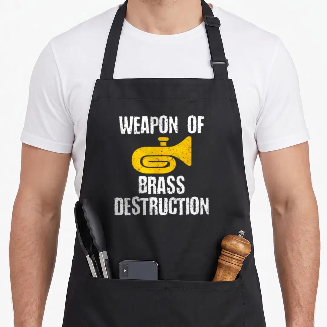 Destruction tuba apron - Yellow trumpet graphic between white distressed text reading WEAPON OF BRASS DESTRUCTION — shown on a black cotton canvas apron against a white background