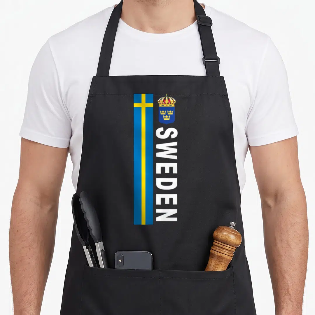 Soccer swedish apron - Vertical SWEDEN text beside blue yellow flag and crowned coat of arms — shown on a black cotton canvas apron against a white background