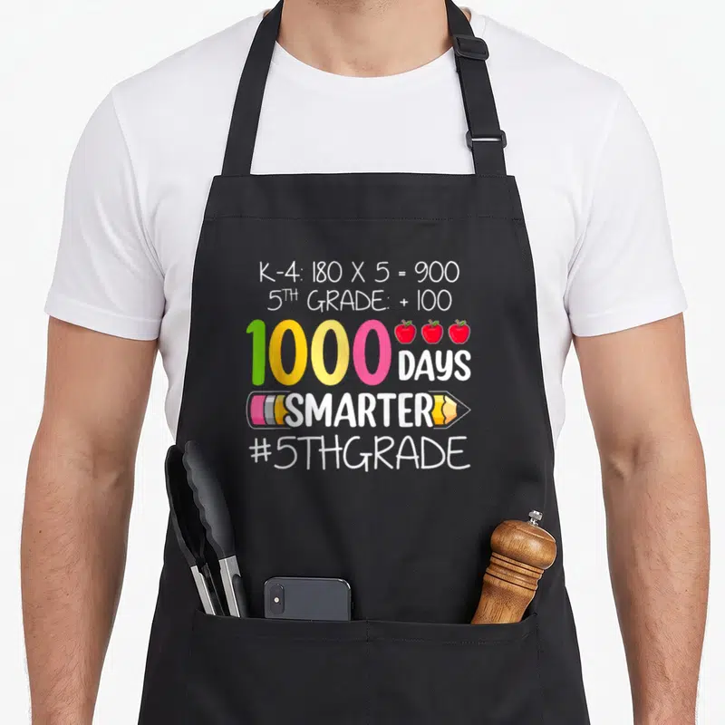 Smarter fifth teacher apron - Colorful 1000 days math equation with three red apples and pencil graphic on black fabric — shown on a black cotton canvas apron against a white background