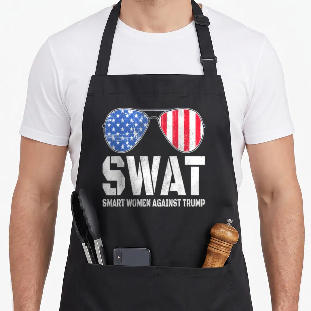 Trump swat bbq apron - Sunglasses with US flag lenses above distressed white SWAT text and slogan — shown on a black cotton canvas apron against a white background