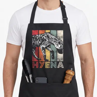 Hyena vintage animal apron - Distressed hyena illustration over five vertical stripes with matching text below — shown on a black cotton canvas apron against a white background