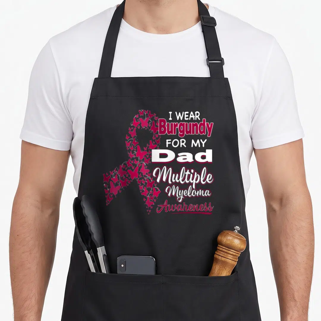 Funny multiple myeloma awareness apron - Burgundy butterfly awareness ribbon with I Wear Burgundy For My Dad text — shown on a black cotton canvas apron against a white background