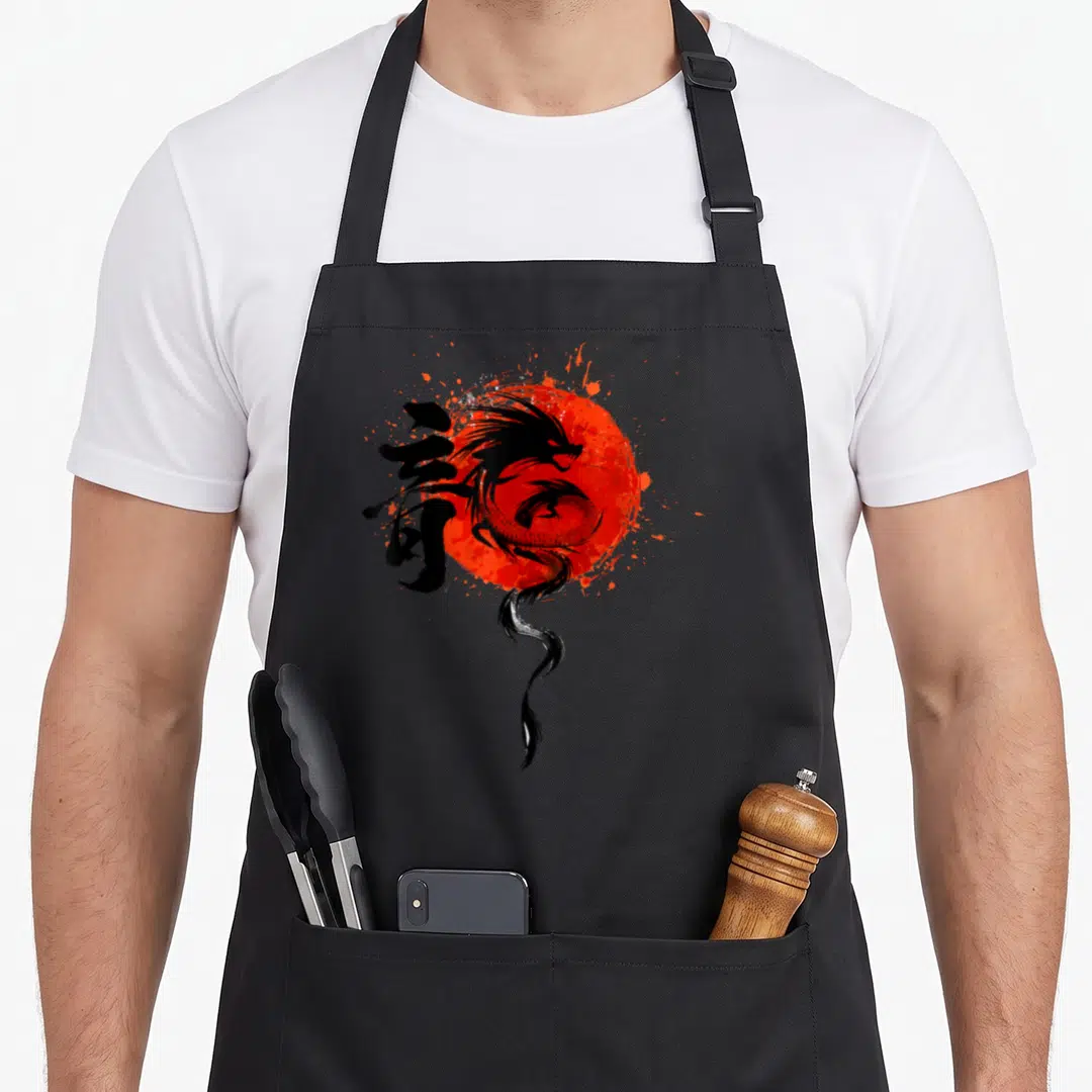 Funny dragon traditional chinese apron - Black dragon silhouette over red sun with calligraphy and splatter effects — shown on a black cotton canvas apron against a white background