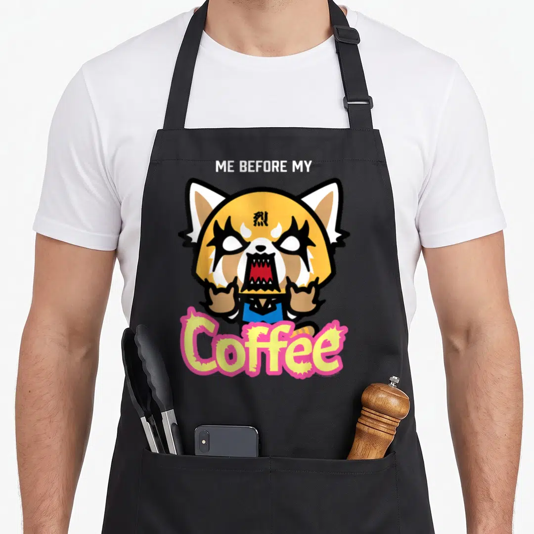 Aggretsuko coffee apron - Cartoon red panda with ME BEFORE MY text and pink Coffee lettering — shown on a black cotton canvas apron against a white background