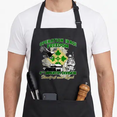 4th operation apron - Operation Iraqi Freedom text with 4th Infantry Division eagle tank soldier emblem in green — shown on a black cotton canvas apron against a white background