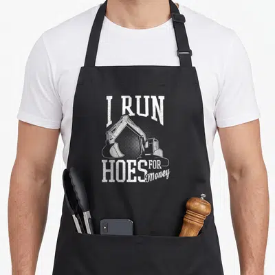 Run heavy canvas aprons - White distressed I RUN HOES FOR Money text framing an excavator silhouette — shown on a black cotton canvas apron against a white background