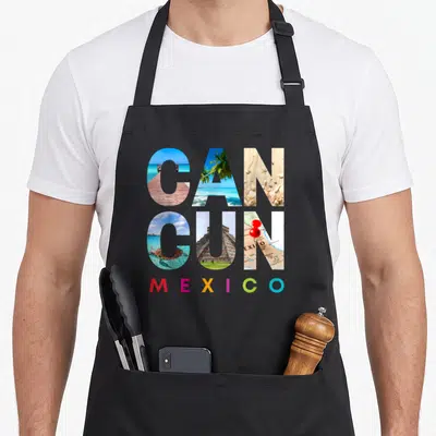 Cancun mexico apron - CANCUN photo letters showing pier turtle pyramid map, MEXICO in red yellow green blue — shown on a black cotton canvas apron against a white background
