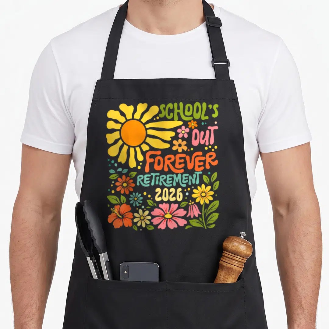Boho teachers apron - Cartoon sun with stacked text reading School's Out Forever Retirement 2026 surrounded by colorful — shown on a black cotton canvas apron against a white background