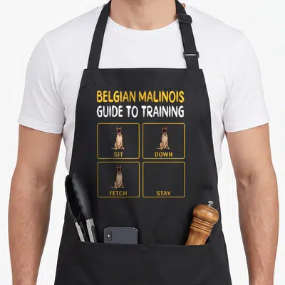 Belgian dog training apron - Cartoon Belgian Malinois in yellow boxes labeled sit down fetch stay with empty final panel — shown on a black cotton canvas apron against a white background