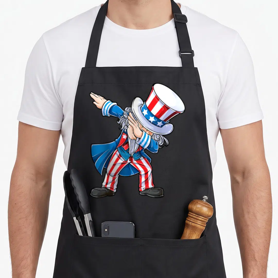 Dabbing 4th of july apron - Cartoon Uncle Sam dabbing in red white and blue stripes — shown on a black cotton canvas apron against a white background