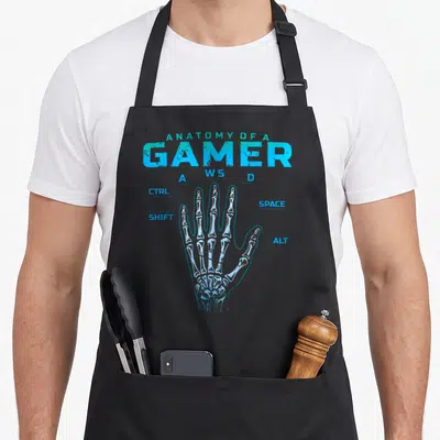 Gamer skeleton apron - Blue skeletal hand diagram labeling fingers as WASD, CTRL, SHIFT, SPACE, and ALT keys — shown on a black cotton canvas apron against a white background