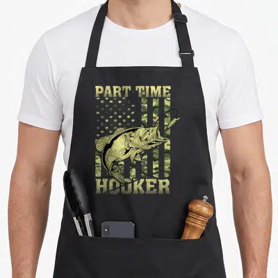 Fishing mens joke aprons - Distressed part-time hooker text over a bass fish on an olive green camouflage flag — shown on a black cotton canvas apron against a white background