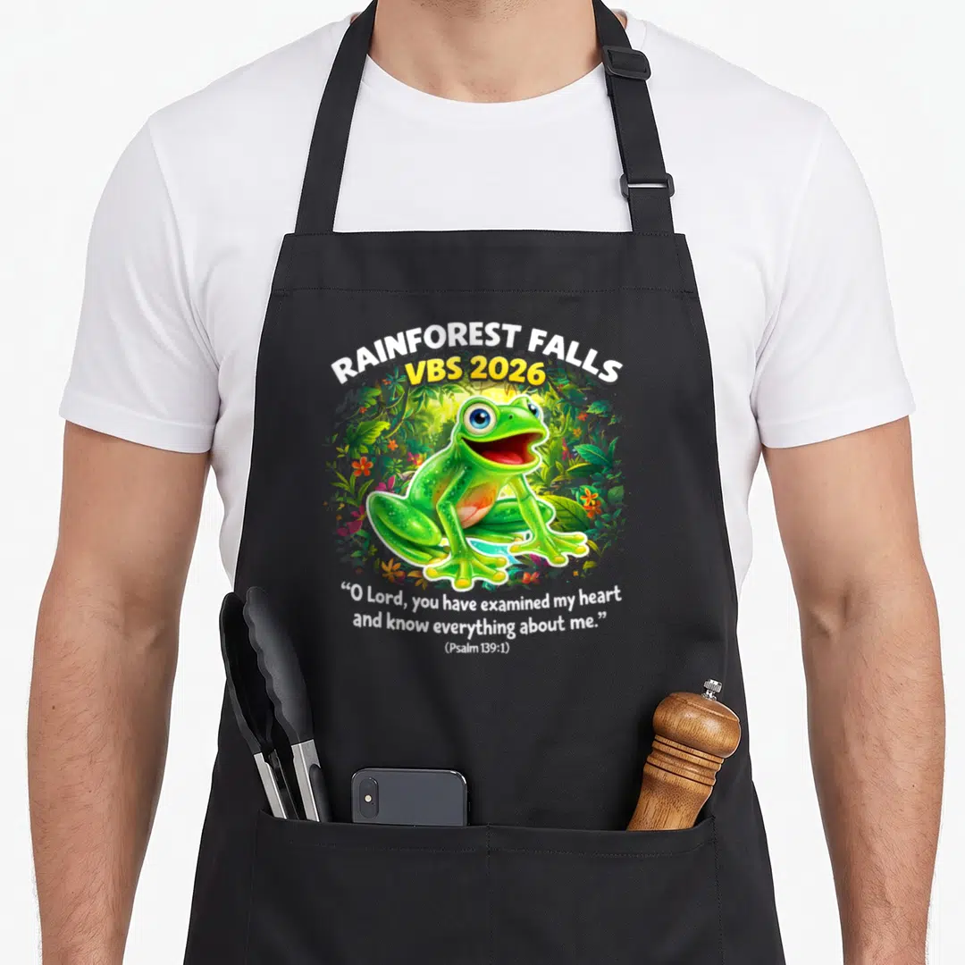 Vbs fall apron - Green cartoon frog surrounded by jungle leaves with VBS 2026 text and Psalm 139:1 quote — shown on a black cotton canvas apron against a white background