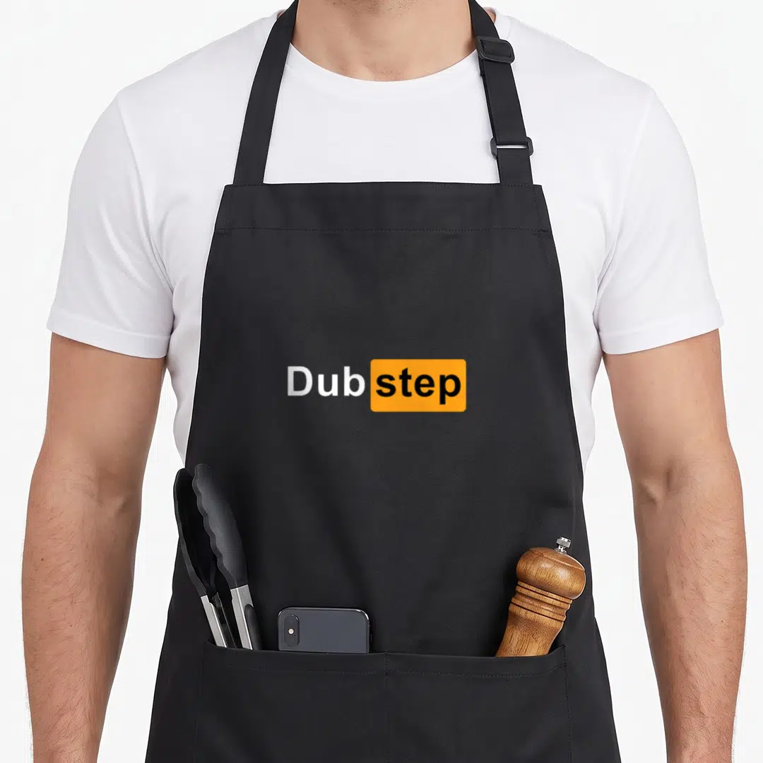 Original dubstep apron - White and orange Dubstep typography on black background — shown on a black cotton canvas apron against a white background