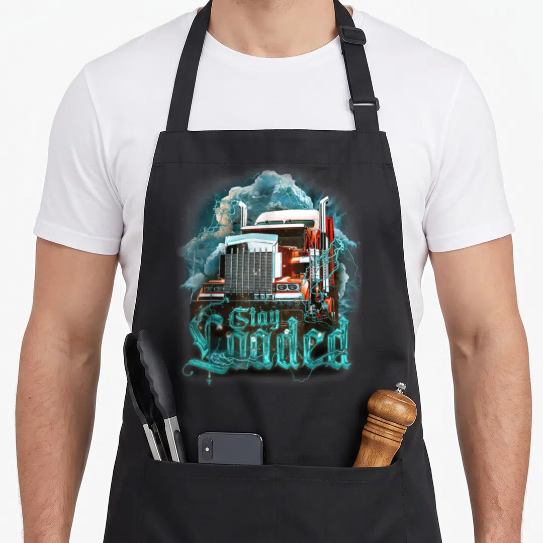 Truckin semi truck apron - Orange semi-truck with cyan lightning and clouds, text reads Gay Loaded in gothic font — shown on a black cotton canvas apron against a white background