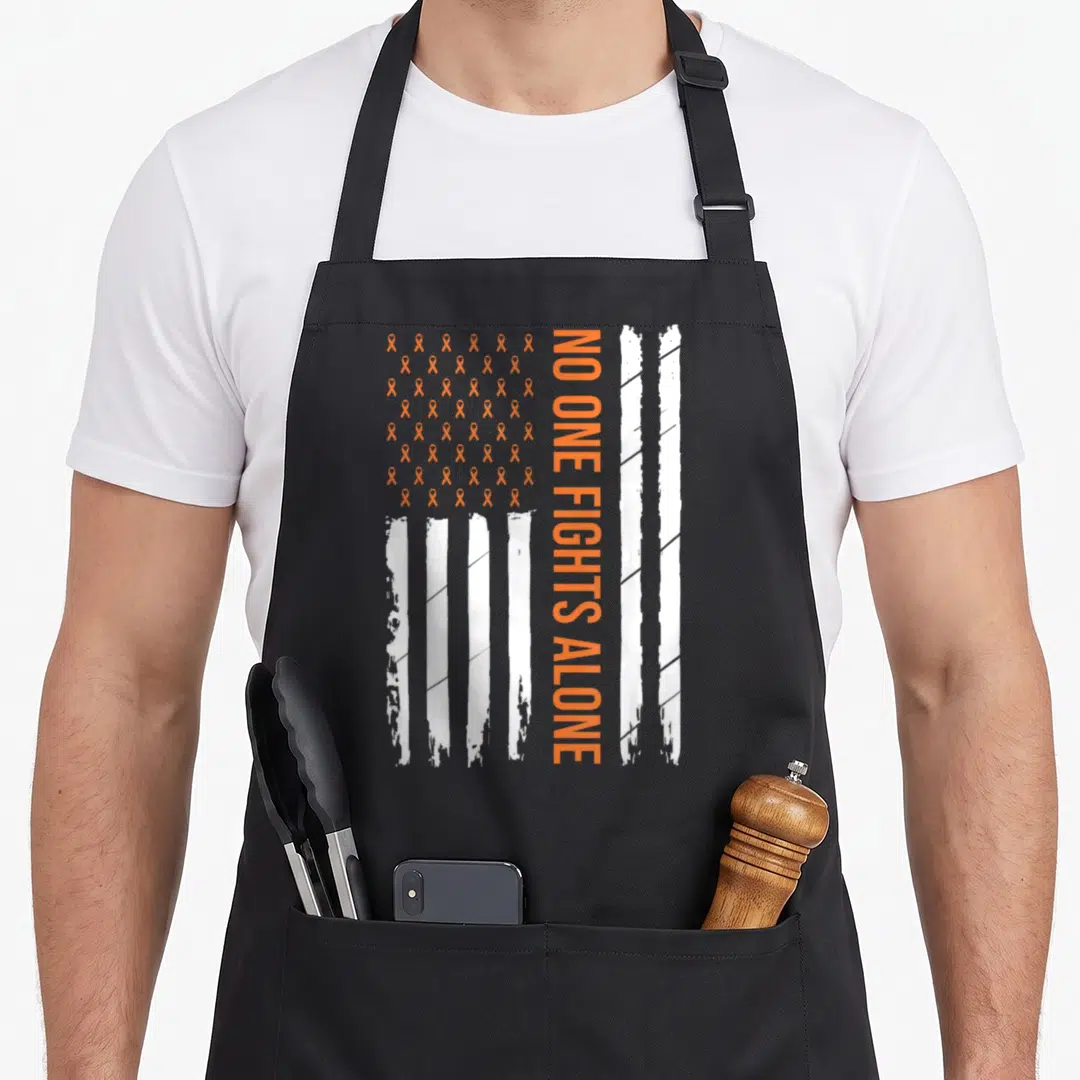 Kidney cancer awareness ribbon apron - Vertical NO ONE FIGHTS ALONE text beside orange ribbon grid and white stripes — shown on a black cotton canvas apron against a white background