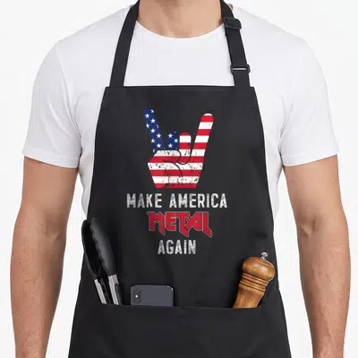 Metal rock heavy apron - Distressed hand gesture with US flag pattern above stacked text Make America Metal Again — shown on a black cotton canvas apron against a white background