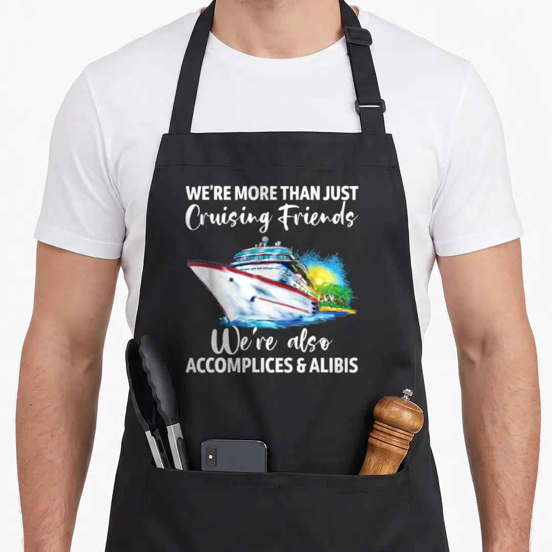 Cruising friends apron - Watercolor cruise ship with tropical beach and accomplices alibis text — shown on a black cotton canvas apron against a white background