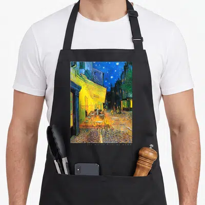 Cafe van gogh apron - Reproduction of the street cafe terrace at night painting in yellow and blue on black fabric — shown on a black cotton canvas apron against a white background
