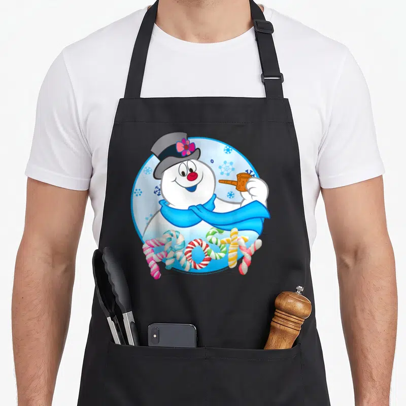 Frosty snowman apron - Cartoon snowman in blue circle with FROSTY written in candy canes — shown on a black cotton canvas apron against a white background