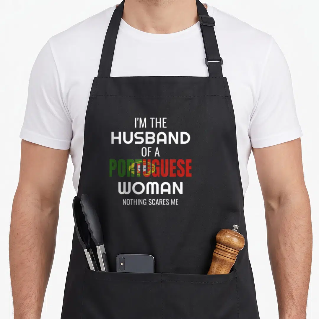 Husband portuguese apron - Stacked text reading I'm the husband of a Portuguese woman nothing scares me with flag colors — shown on a black cotton canvas apron against a white background