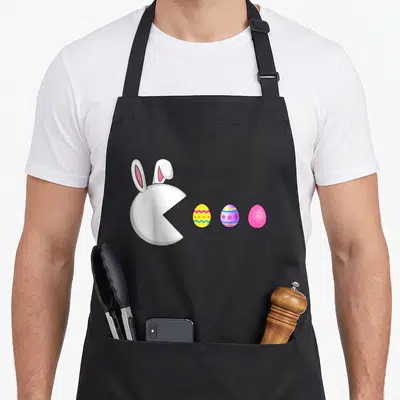 Game easter egg apron - White bunny head facing three yellow purple and pink decorated Easter eggs in cartoon style — shown on a black cotton canvas apron against a white background
