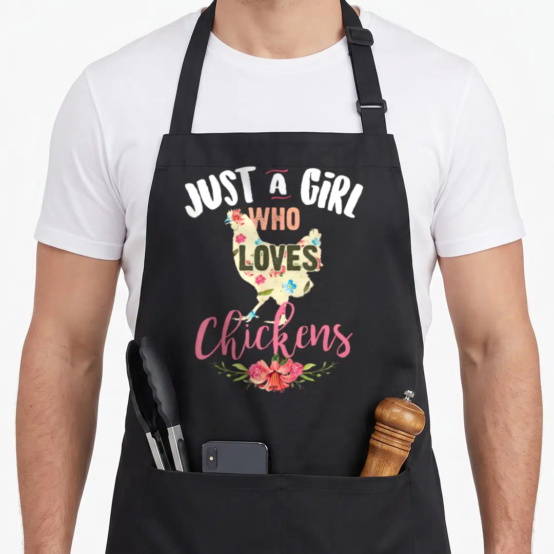 Poultry chicken apron - Floral chicken silhouette with arched text JUST A GIRL WHO LOVES Chickens and bottom bouquet — shown on a black cotton canvas apron against a white background
