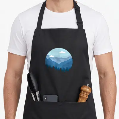 Blue mountain girl apron - Circular blue mountain landscape with pine trees and white clouds in minimalist style — shown on a black cotton canvas apron against a white background