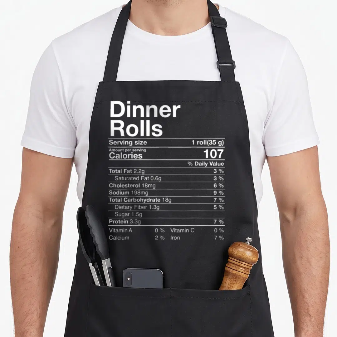 Roll thanksgiving day aprons - White typography nutrition facts label for dinner rolls listing calories and nutrients — shown on a black cotton canvas apron against a white background