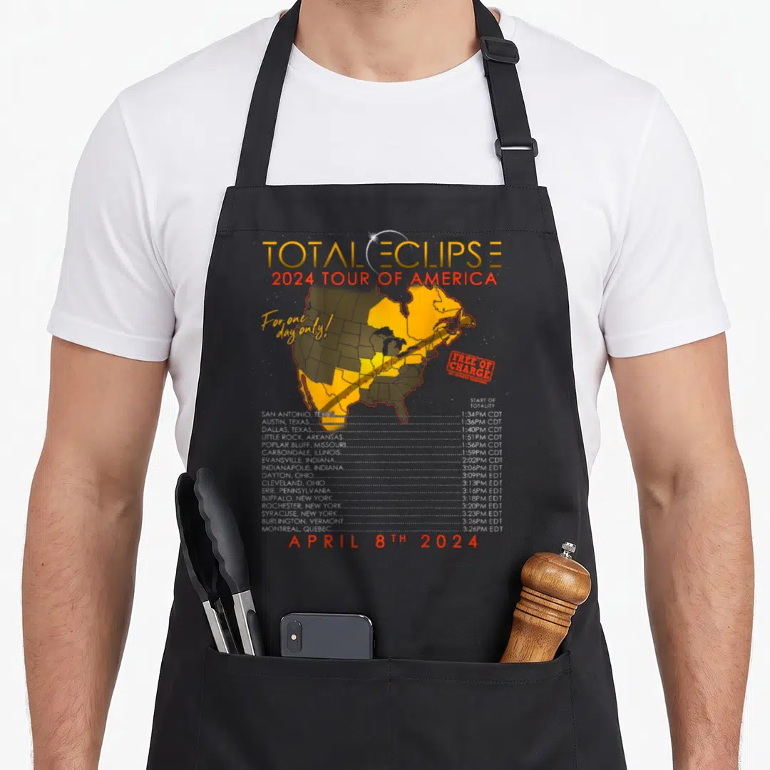 Tour eclipse apron - Map of North America showing yellow totality path with city times and 2024 eclipse date — shown on a black cotton canvas apron against a white background